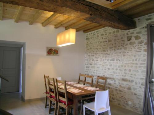 une salle à manger avec une table et des chaises en bois dans l'établissement Gîte spacieux avec jardin, terrasse, BBQ et cheminée - FR-1-489-4, à Chirat-lʼÉglise