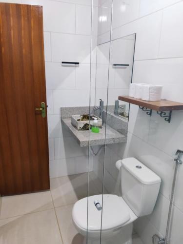 a bathroom with a toilet and a glass shower at Sítio Martinelli, Caravaggio in Santa Teresa
