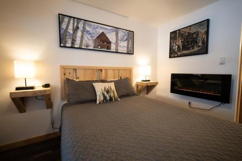 Alpine Lodge Hotel في Cascade: غرفة نوم مع سرير وتلفزيون بشاشة مسطحة