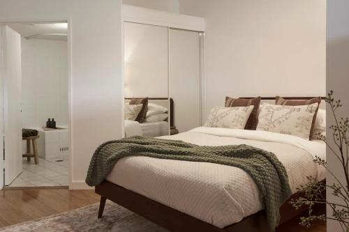 ein Schlafzimmer mit einem großen Bett und einem Spiegel in der Unterkunft Surry Hills Loft-Style Heritage 1BR - Indoor Pool, Sauna & Gym in Sydney