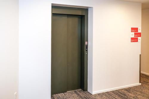 a elevator in a building with a green door at Airport Stays in Wellington