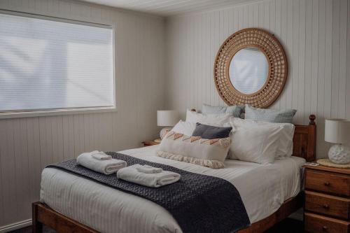 a bedroom with a large bed with towels on it at Sea Breeze Freycinet - Hot Tub in Coles Bay