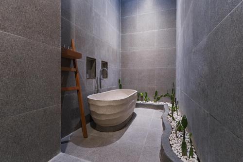 a bathroom with a bath tub in the corner at Villa Shekinah Oasis in Ubud