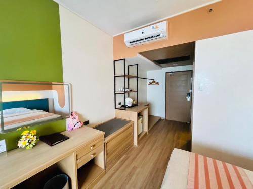 a room with a bed and a desk with a mirror at Asia Cha-am Hotel in Cha Am