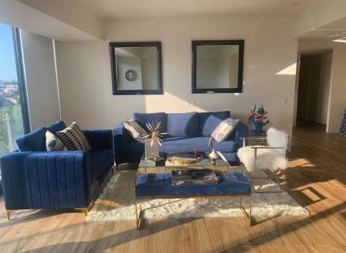 a living room with a blue couch and a table at Departamento Superior 4H-61 in Guadalajara