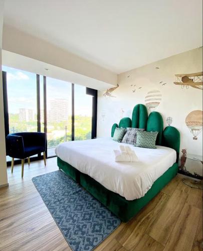 a bedroom with a large bed with a green headboard at Departamento Superior 4H-61 in Guadalajara