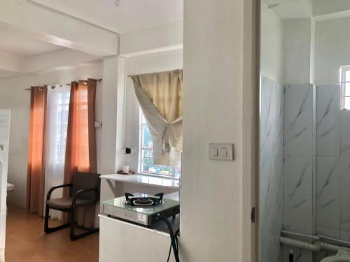 a kitchen with a stove and a table in a room at Elatap Studio Overlooking Baguio in Baguio