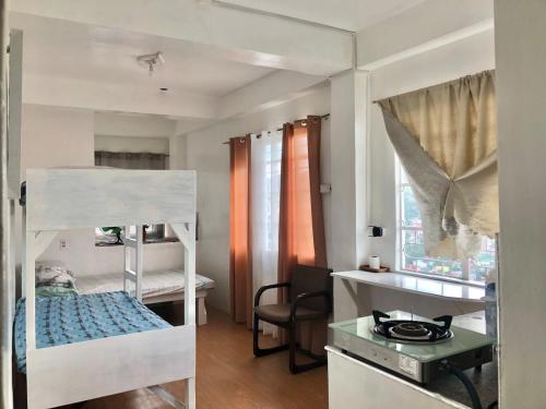 a room with two bunk beds and a desk at Elatap Studio Overlooking Baguio in Baguio
