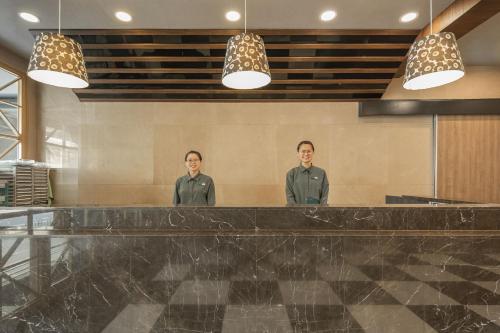 two men standing behind a counter in a restaurant at 康橋商旅台南赤崁樓館 in Tainan