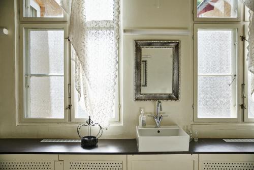 ein Badezimmer mit einem Waschbecken und zwei Fenstern in der Unterkunft Danhostel Aarhus in Arhus