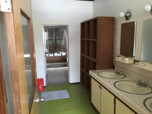 a bathroom with two sinks and a shower at Towadako Hostel in Towada