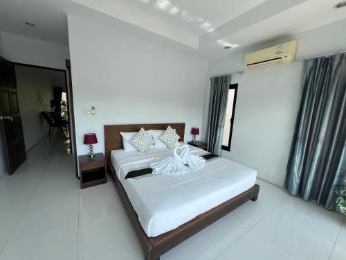 a bedroom with two beds and a mirror at Nern Khao Guest House in Kamala Beach