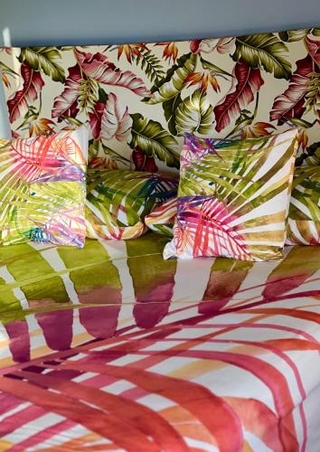 a group of pillows on a bed with a pattern at Les Chalets de Afaahiti - Fare Keanu in Tiitau