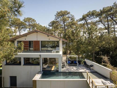une maison avec une piscine devant dans l'établissement Villa luxueuse avec piscine privée à Hossegor - FR-1-791-2, à Soorts-Hossegor