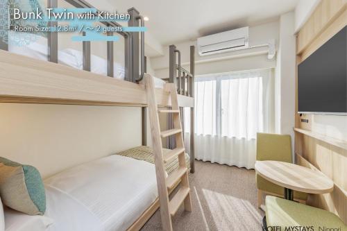 a bedroom with two bunk beds and a tv at HOTEL MYSTAYS Nippori in Tokyo