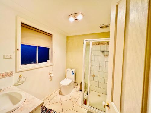 Un baño con inodoro, lavabo y ducha. en An Ensuite Comfort in Sydenham, en Sydenham