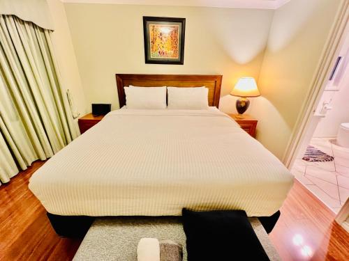 a bedroom with a large white bed in a room at An Ensuite Comfort in Sydenham in Sydenham