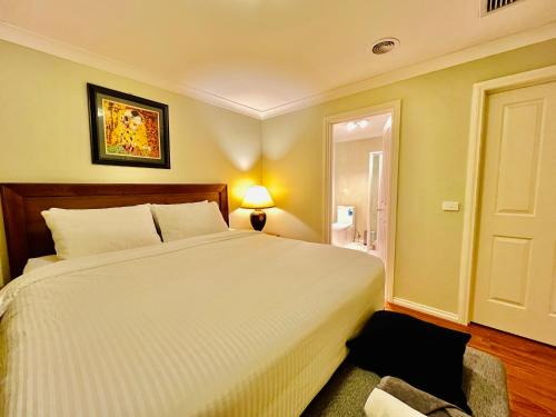 a bedroom with a large white bed in a room at An Ensuite Comfort in Sydenham in Sydenham