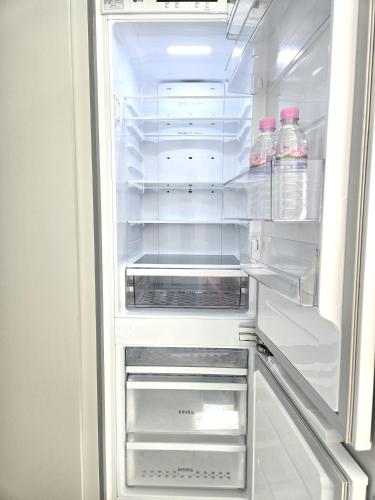 an open refrigerator with bottles of water in it at Nampo The Bayment BLINGEASTERN in Busan