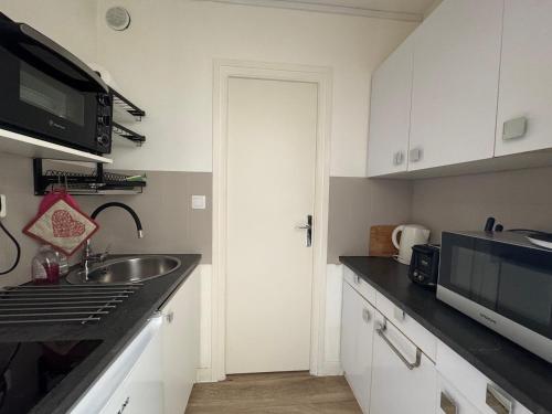 une cuisine avec un évier et un micro-ondes dans l'établissement Studio moderne et cosy, bien situé, vue montagne, wifi - FR-1-555-114, à Aix-les-Bains