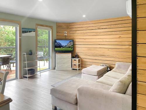 Una sala de estar con un sofá y un televisor. en Alpine Edge Retreat- Gateway to Mount Buller, en Merrijig