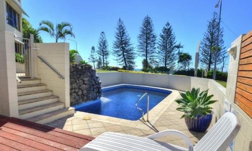 una piscina en un patio trasero con 2 sillas en Bellardoo12- Mooloolaba Beach, en Mooloolaba