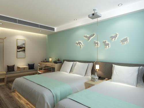 a bedroom with two beds and a wall with birds at Happy Dragon Universal Vacation Hotel - close to Universal Studio and Wanda Plaza,free shuttle to the Resort,Free Coffee,Laundry in Beijing