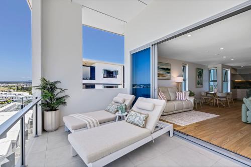 a living room with white furniture and a balcony at Azzure Bokarina Penthouse- Brand New- Ocean View- Resort Style Pool- Steam Room in Bokarina