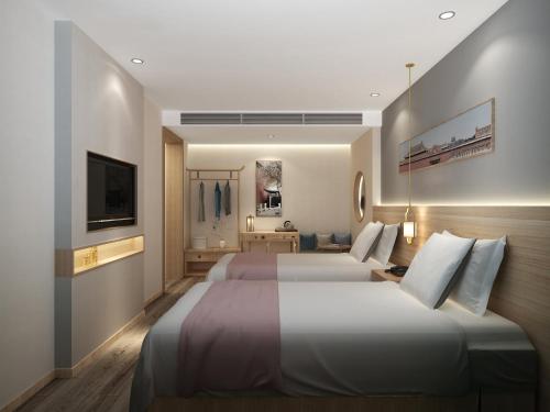 a hotel room with two beds and a television at Happy Dragon Universal Vacation Hotel - close to Universal Studio and Wanda Plaza,free shuttle to the Resort,Free Coffee,Laundry in Beijing
