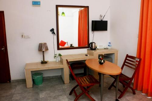 a room with a desk and a table and a mirror at Sea Shine Beach Hotel in Uswetakeiyawa