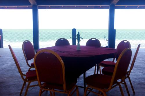 a dining room table with chairs and a view of the ocean at Sea Shine Beach Hotel in Uswetakeiyawa