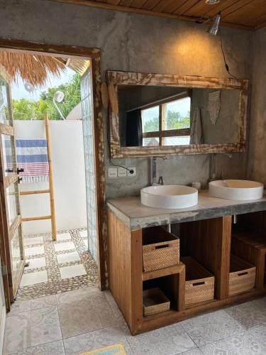 a bathroom with two sinks and a mirror at Pink Door Villa Gili Air, private pool & kitchen in Gili Air