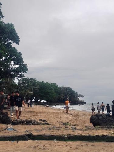 a group of people walking on a beach at Arga Hostelry in Kareo