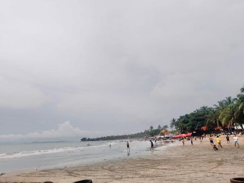 a group of people walking on a beach at Arga Hostelry in Kareo
