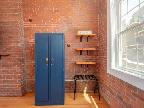 プロビデンスにあるJennifer's Historic Brick Riverfront Loft Apartmentの窓の隣に青いドアがあるレンガの壁