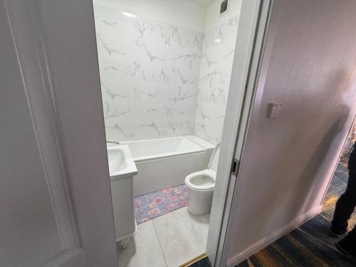 une salle de bains blanche avec toilettes et lavabo dans l'établissement Capital Tower, à Oulan-Bator