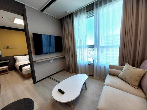 a living room with a couch and a tv at Nampo The Bayment BLINGEASTERN in Busan