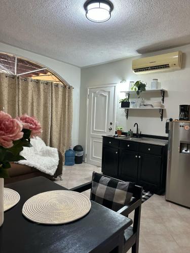 a kitchen and living room with a table and a refrigerator at Modern and Cozy Loft in La Ceiba