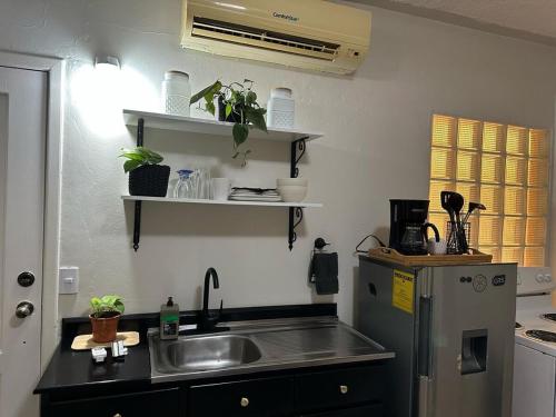 a kitchen with a sink and a refrigerator at Modern and Cozy Loft in La Ceiba