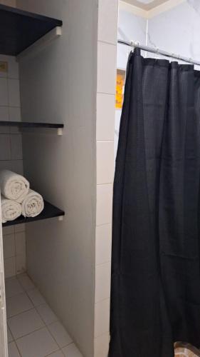 a shower with a black shower curtain in a bathroom at Modern and Cozy Loft in La Ceiba