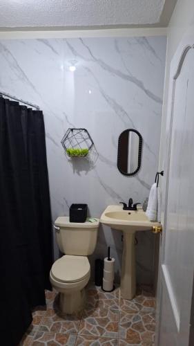 a bathroom with a toilet and a sink at Modern and Cozy Loft in La Ceiba