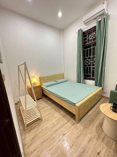 a bedroom with a bed and a chair in it at Nhà Happy in Hanoi