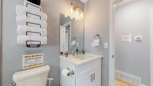 a bathroom with a toilet and a sink and a mirror at Updated Family Unit with Two King Beds in Denver