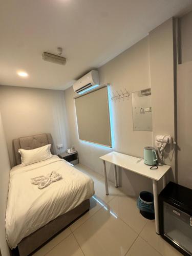 a small room with a bed and a desk at Georgetown Hotel in George Town