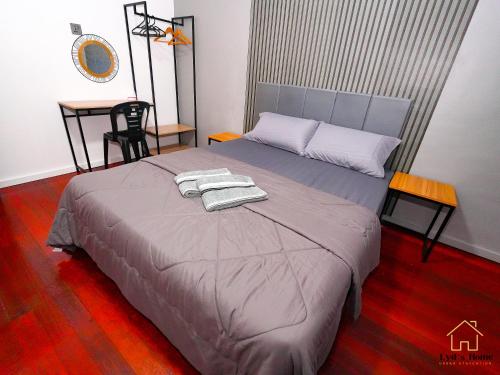 a bedroom with a bed with two towels on it at Lyd's Home Urban Staycation in Sibu