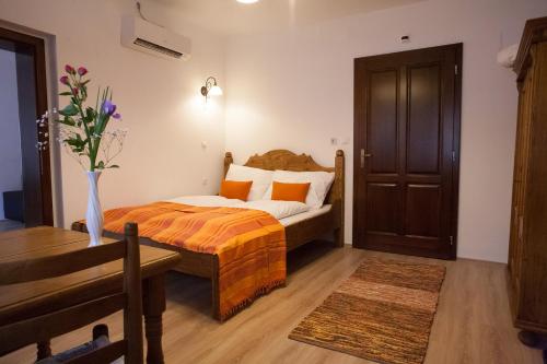 a bedroom with a bed and a table with a vase of flowers at Maushaus in Véménd