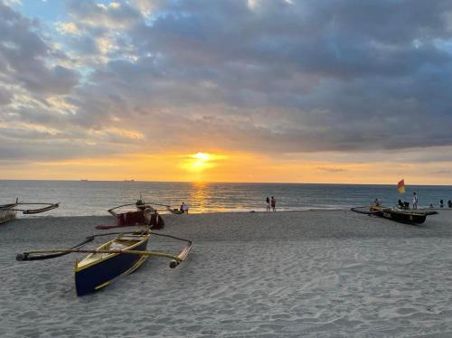 a beach with two boats on the sand at sunset at Beach front deluxe room with bathroom - Modern Cabin Shiloh 2 in San Narciso