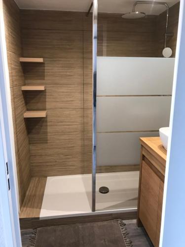 une douche avec une porte vitrée dans une salle de bain dans l'établissement Magnifique studio Cassis vue mer, à Cassis