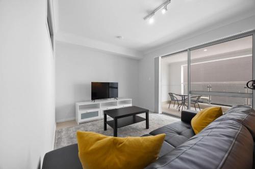 a living room with a couch and a television at Sun Sand & Style Cozy 2BR Coastal Retreat in Rockingham in Rockingham