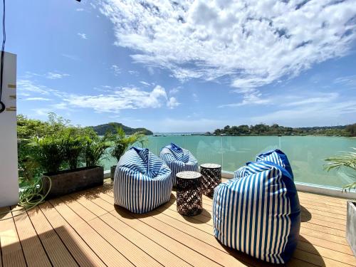 four blue and white chairs on a deck with a view of the water at Seaview Duplex Home - Panwa Beach - Baan Jayden in Phuket